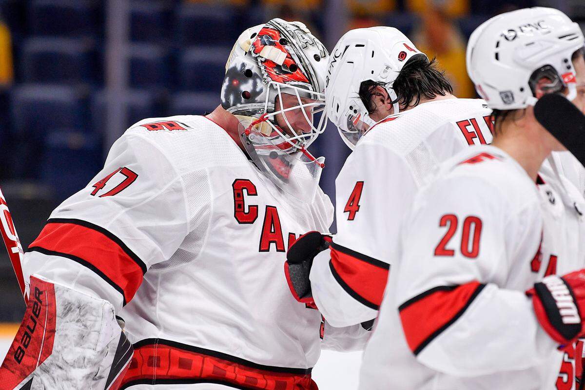 Carolina Hurricanes goaltender James Reimer (47) celebrates defeating the Nashville Predators 4-2 with defenseman Haydn Fleury (4) after an NHL hockey game in Nashville, Tenn., Monday, Jan. 18, 2021. (Andrew Nelles/The Tennessean via AP)