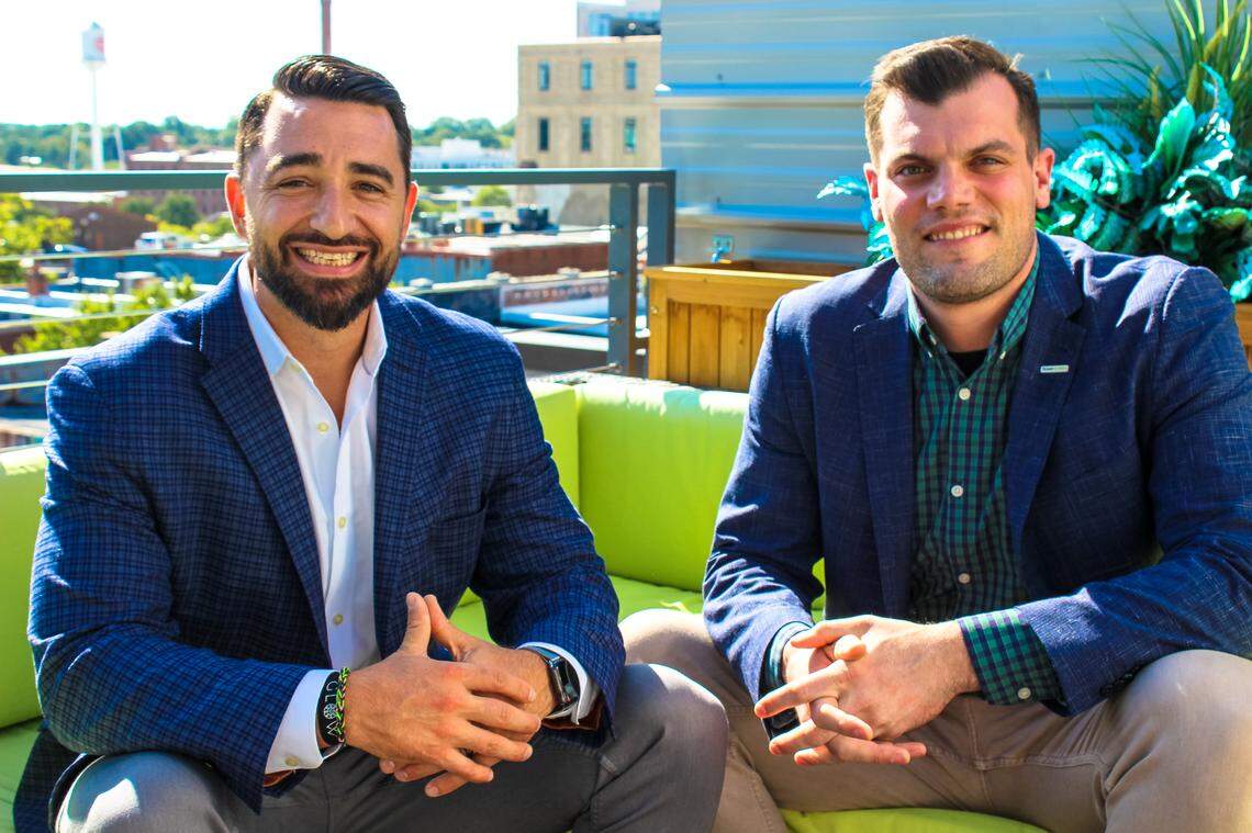 Jim Cavale, founder of INFLCR, left and Zach Maurides, the CEO of Teamworks, right, pose for a photo in downtown Durham. Teamworks said that it has taken an ownership stake in INFLCR.