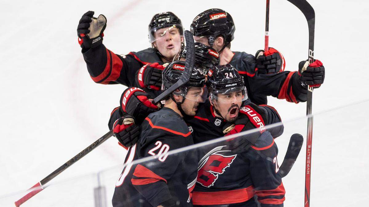 Carolina Hurricanes center Sebastian Aho (20) is surrounded by teammates including center Seth Jarvis (24) after scoring in the second period to tie New Jersey 4-4 during Game 5 of their Stanley Cup series on Tuesday, April 29, 2025, at Lenovo Center in Raleigh, N.C.