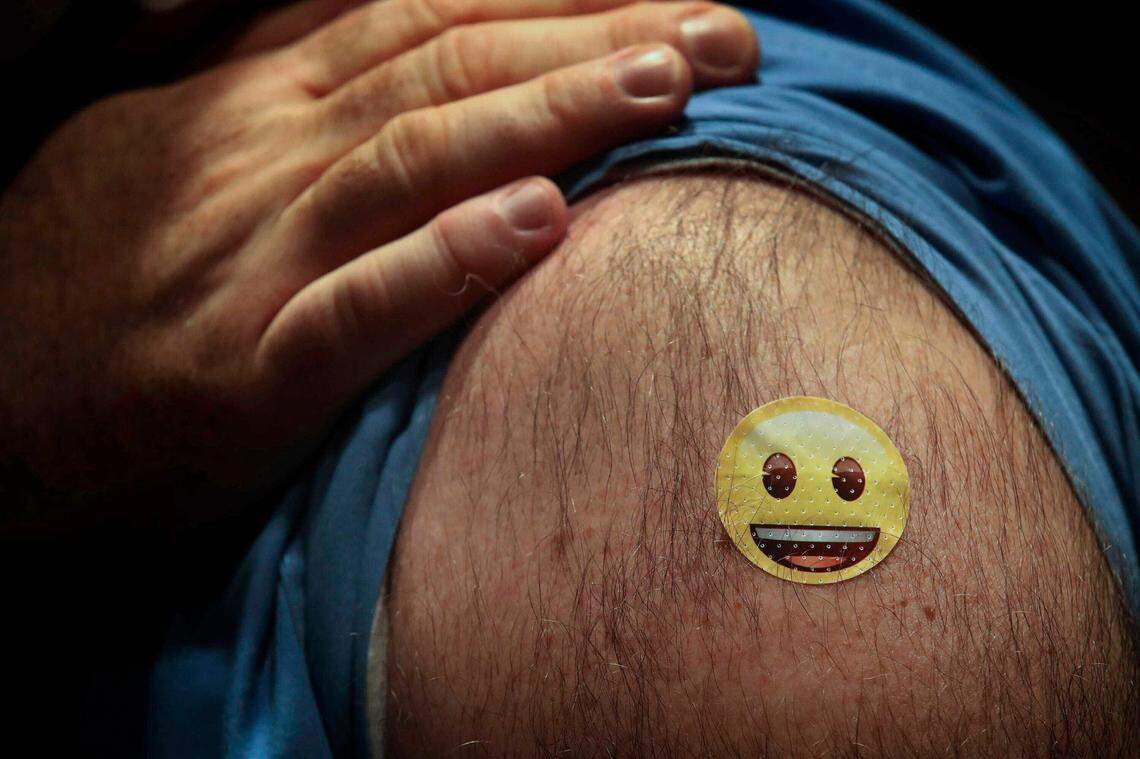 A quarter-size bandage covers the vaccination spot for Dr. Jason Smith, chief medical officer and trauma surgeon at UofL hospital in Louisville, Ky. Smith became the first person in the state of Kentucky to receive the COVID-19 vaccine on Monday, Dec. 14, 2020.