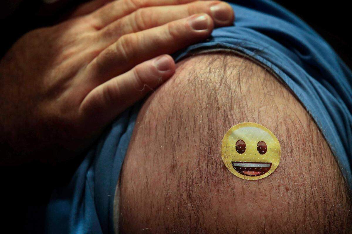 A quarter-size bandage covers the vaccination spot for Dr. Jason Smith, chief medical officer and trauma surgeon at UofL hospital in Louisville, Ky. Smith became the first person in the state of Kentucky to receive the COVID-19 vaccine on Monday, Dec. 14, 2020.