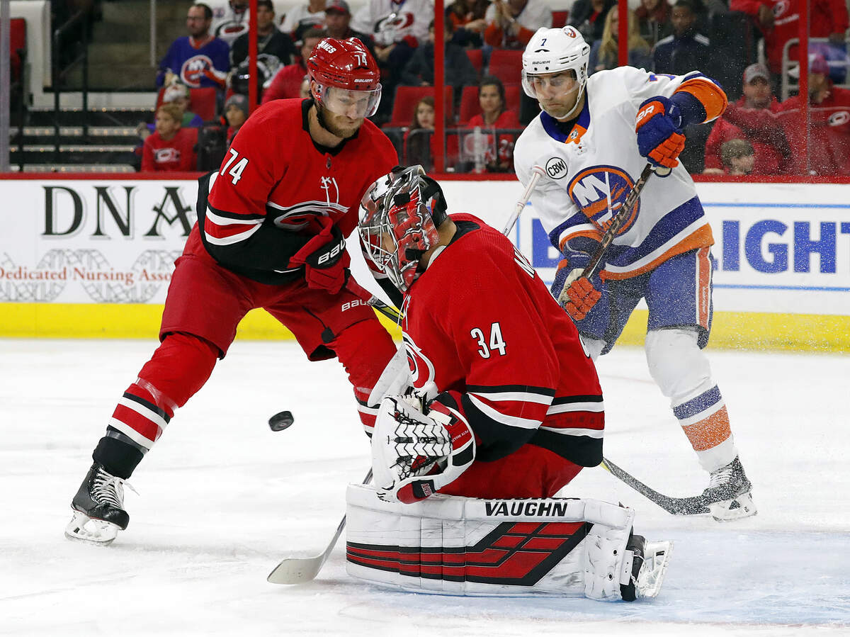 Carolina Hurricanes goaltender Petr Mrazek (34), of the Czech Republic, blocks the shot of New York Islanders’ Jordan Eberle (7) with Hurricanes’ Jaccob Slavin (74) nearby during the first period of an NHL hockey game, Sunday, Oct. 28, 2018, in Raleigh, N.C. 