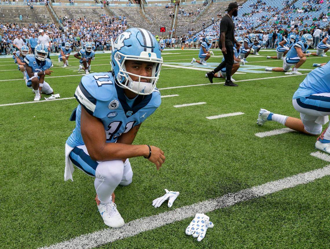 North Carolina’s Josh Downs (11) stretches with his teammates prior to the Tar Heels’ game against Notre Dame on Saturday, September 24, 2022 at Kenan Stadium in Chapel Hill, N.C.