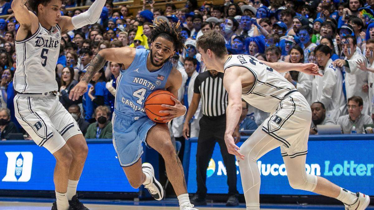 North Carolina’s R.J. Davis (4) drives to the basket between Duke’s Tyrese Proctor (5) and Kyle Filipowski (30) in the second half on Saturday, February 4, 2023 at Cameron Indoor Stadium in Durham, N.C.