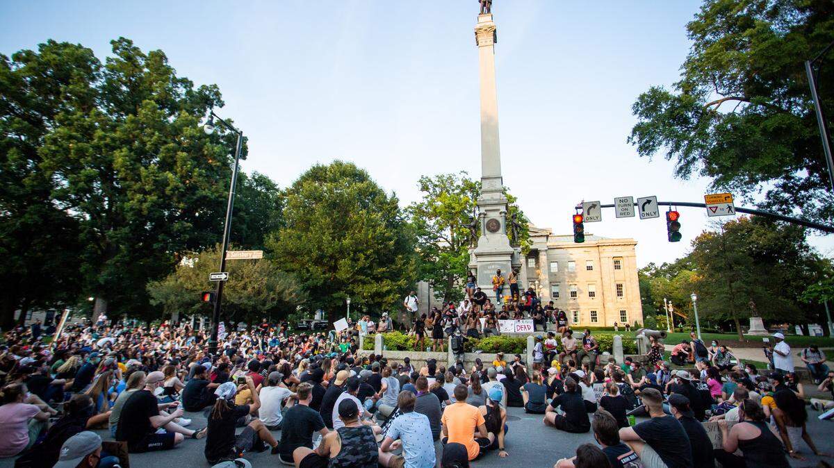 Protesters gather at the base of a Confederate monument outside the North Carolina State Capitol building in Raleigh, N.C. on Thursday, Jun. 4, 2020. The group gathered to protest the death of George Floyd, who was killed by a police officer in Minneapolis. The monument and two others honoring the Confederacy were removed later that month. A proposed monument honoring African Americans is still awaiting state funding.