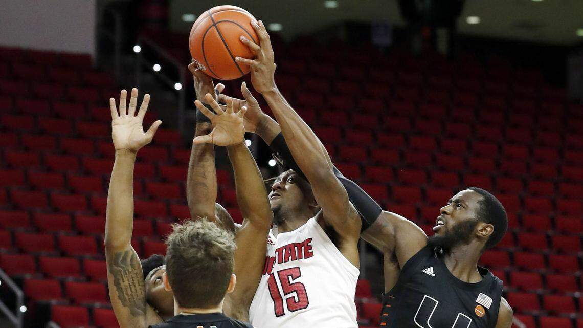 N.C. State’s Manny Bates (15) pulls in the rebound from Miami’s Elijah Olaniyi (4) during the first half of N.C. State’s game against Miami at PNC Arena in Raleigh, N.C., Saturday, January 9, 2021.