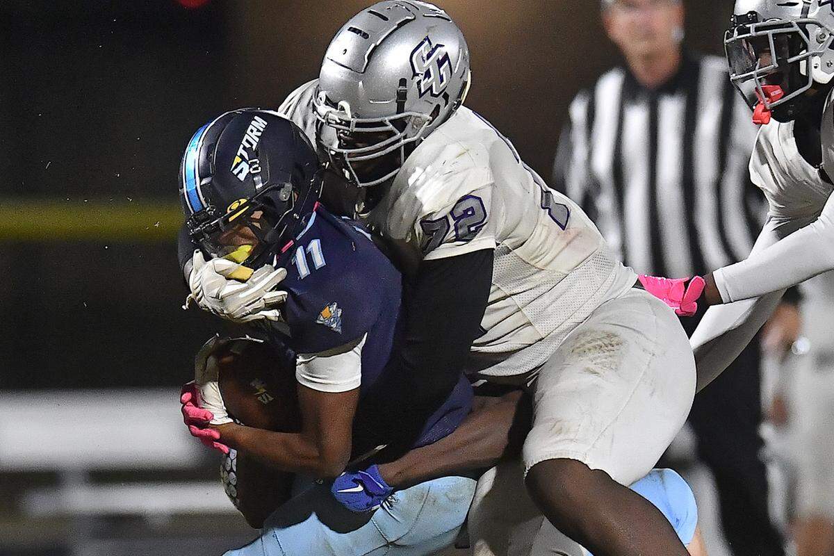 South Garner lineman Ekene Ogboko (72) tackles Willow Spring running back Amir Wallace (11) during the second half. The Willow Spring Storm and the South Garner Titans met in a football game in Fuquay-Varina. N.C. on October 18, 2024.