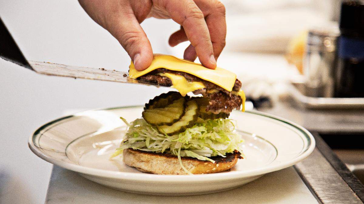 Chef Chris Lopez plates Fine Folk’s Smash Burger on Wednesday, Oct. 6, 2021.