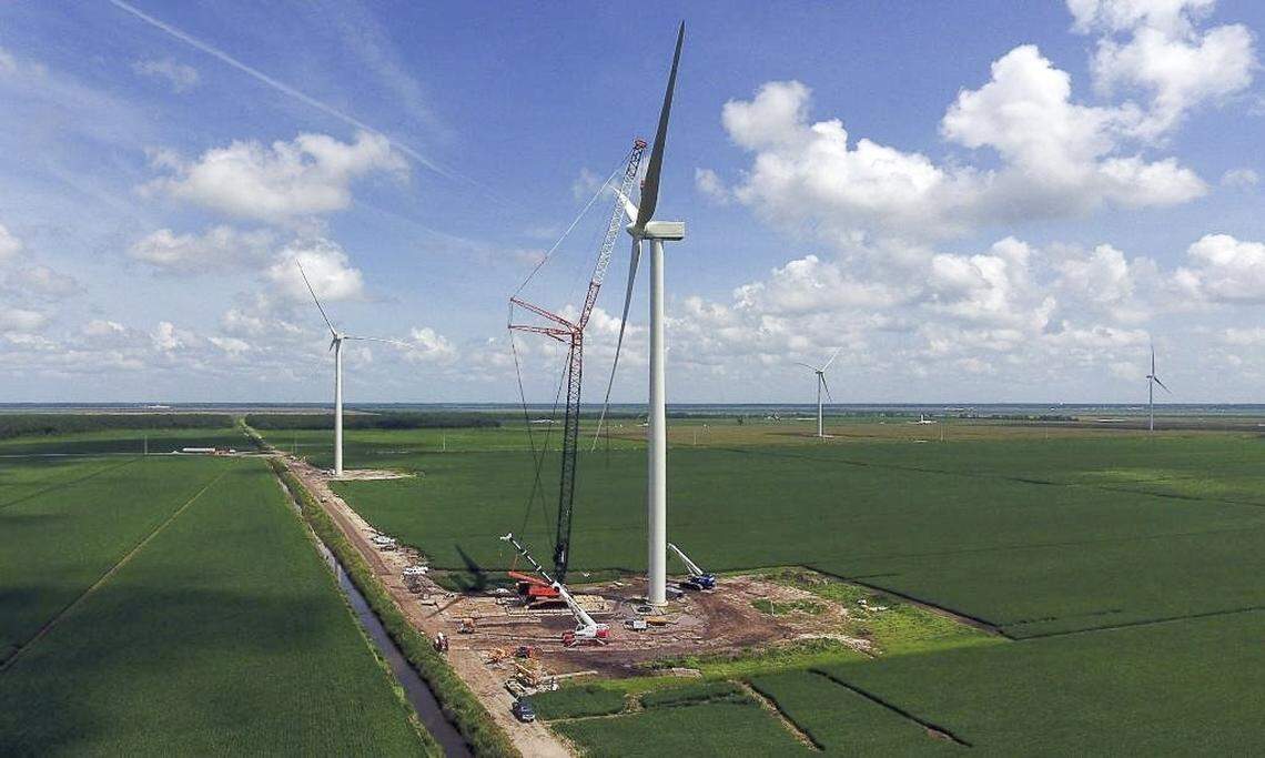 A large crane holds the blade assembly as it is attached to the nacelle Aug. 10, 2016, at the Amazon Wind Farm near Elizabeth City, N.C. The nacelle contains a generator and turbine.