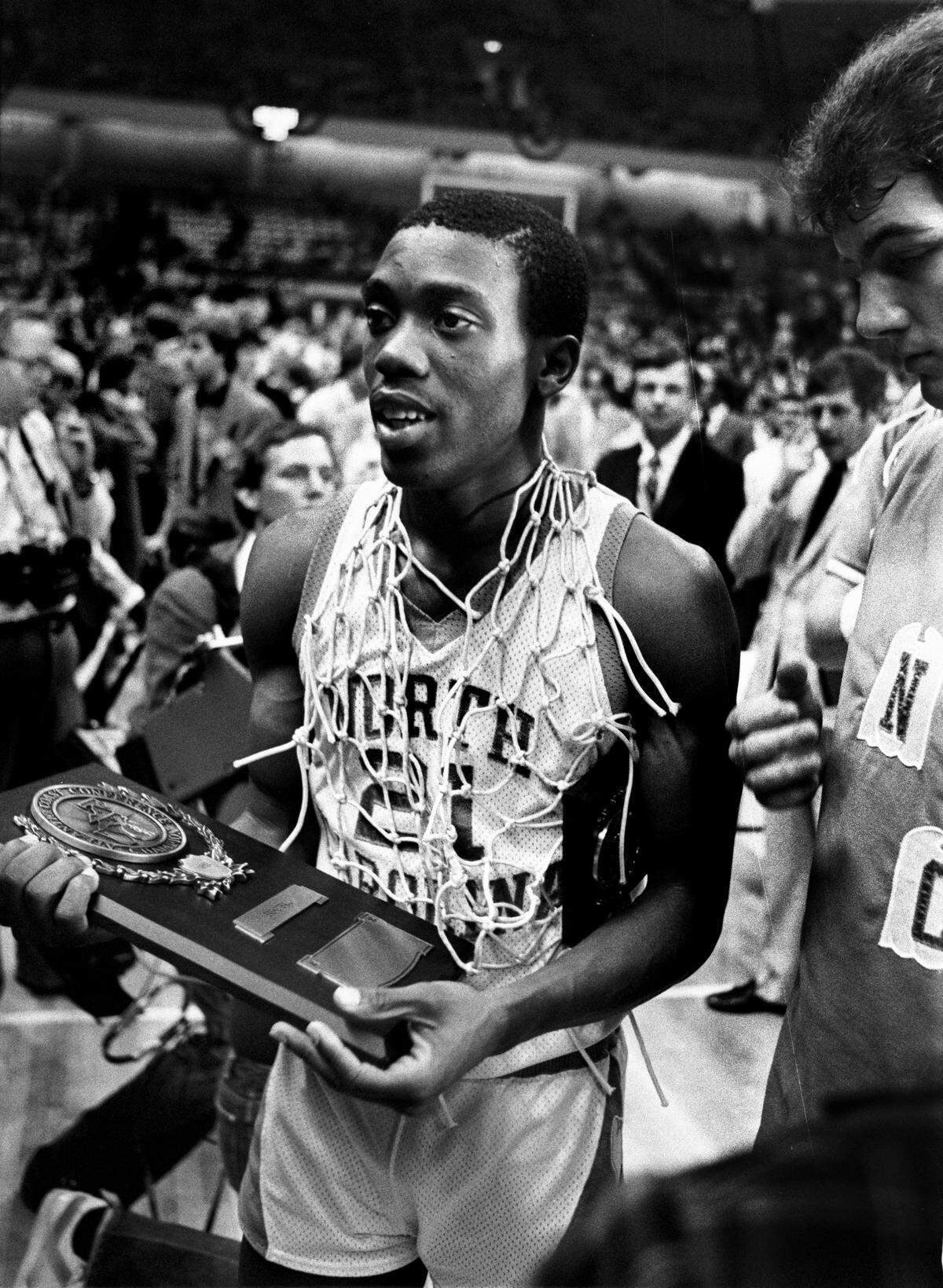 UNC's Jimmy Black wears one of the nets as he holds a trophy following the Tar Heels win over Virginia in the 1982 ACC Tournament championship game.