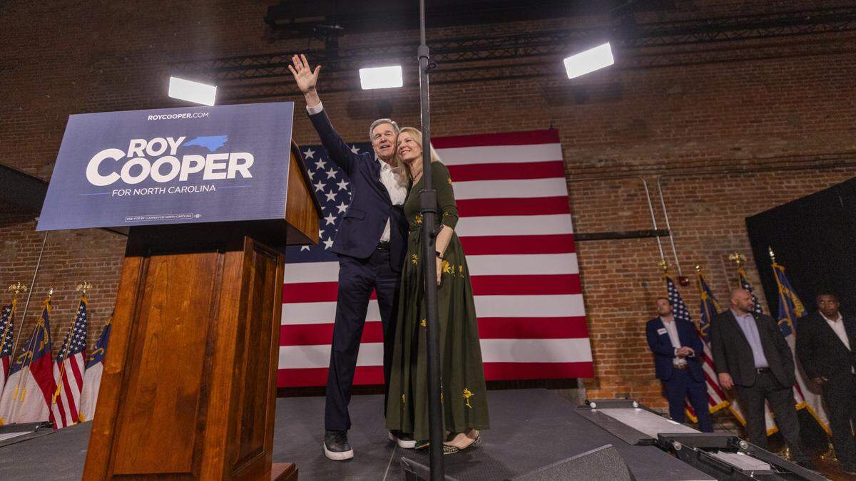 Former Gov. Roy Cooper and his wife Kristin wave to supporters at the conclusion a “Make Stuff Cost Less” campaign rally on Thursday, April 9, 2026, at Bay 7 in Durham’s American Tobacco Campus. Cooper faces former Republican National Committee Chairman Michael Whatley in the race for U.S. Senate. Both are vying to replace Sen. Thom Tillis, a Republican from Huntersville, who is retiring at the end of his term.