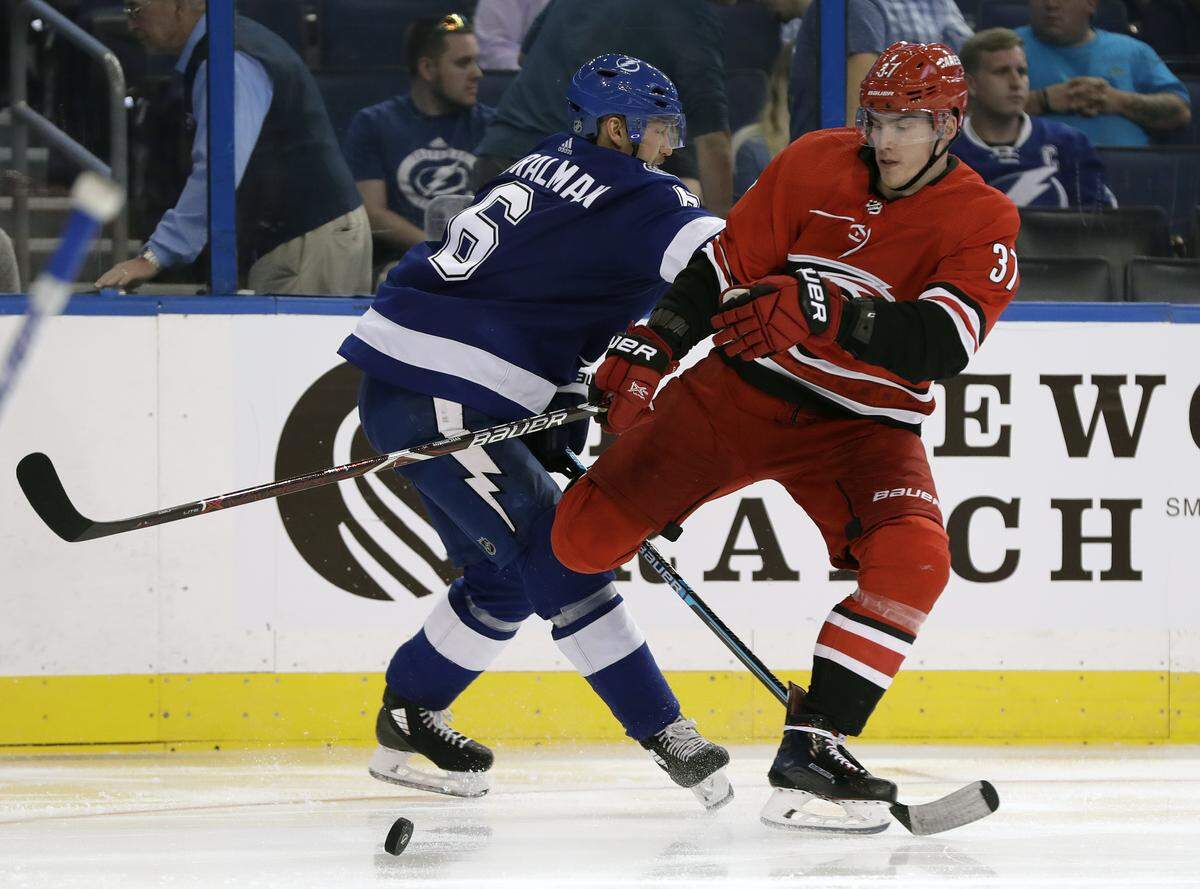 Carolina Hurricanes forward Andrei Svechnikov, right, fights Tampa Bay Lightning defenseman Anton Stralman for the puck in preseason game Sept. 18, 2018, in Tampa, Fla.