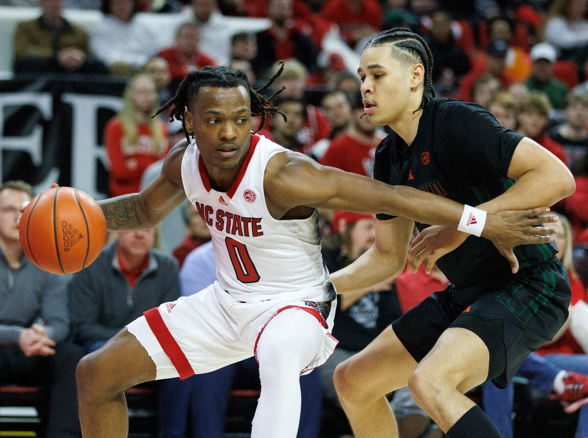 N.C. State’s DJ Horne drives past Miami’s Kyshawn George during the second half of the Wolfpack’s 74-68 win on Tuesday, Jan. 30, 2024, at PNC Arena in Raleigh, N.C.