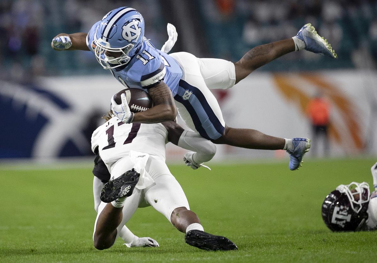 North Carolina’s Josh Down (11) is stopped by Texas A&M’s Jaylon Jones (17) on third down setting up the Tar Heels’ first field goal in the first quarter in the Capital One Orange Bowl on Saturday, January 2, 2021in Miami Gardens, Florida.