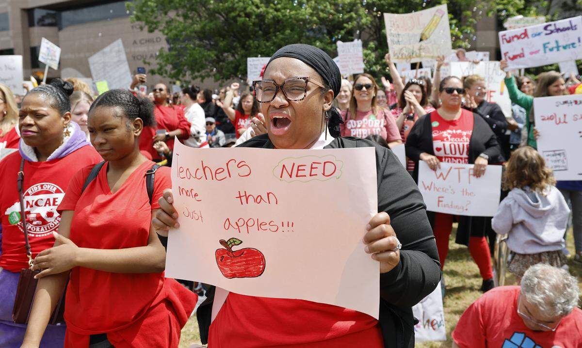 Sharie Taylor-Covington, a teacher at Zebulon Elementary School, cheers on the speakers during a rally to protest for more school funding at Halifax Mall in downtown Raleigh, N.C., Friday, May 1, 2026.  The North Carolina Association of Educators has mobilized teachers from across the state to march on the Legislative Building to demand higher pay, more school funding and higher taxes on corporations. 