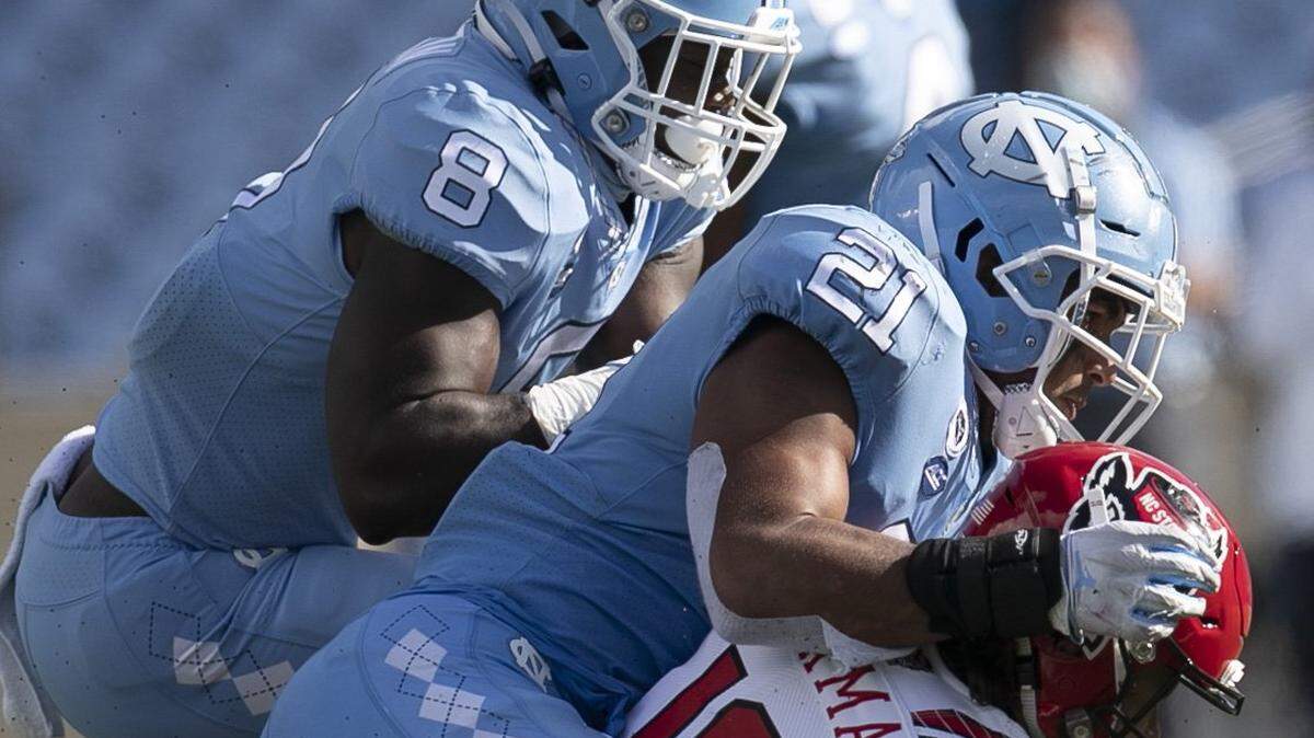 N.C. State quarterback Bailey Hockman (16) is sacked by North Carolina’s Chazz Surratt (21) and Khadry Jackson (8) in the fourth quarter at Kenan Stadium on Saturday, October 24, 2020 in Chapel Hill, N.C.