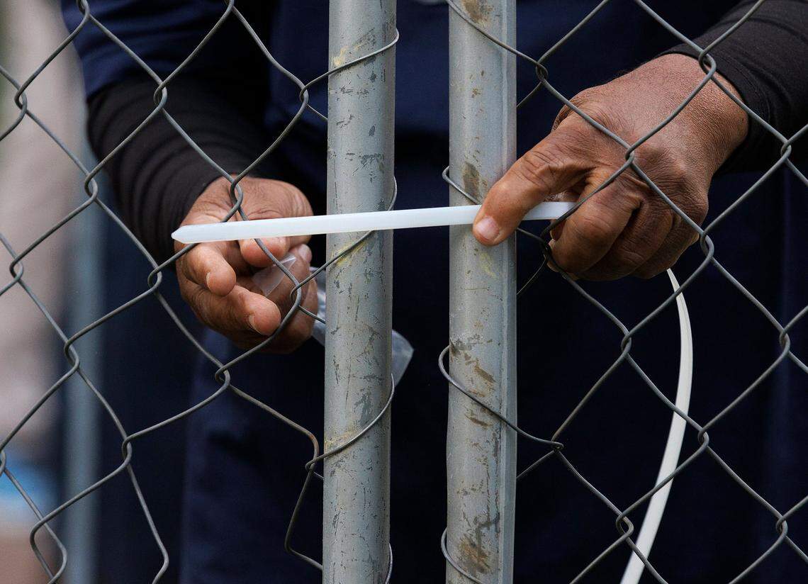 A person secures a fenced barrier around a flagpole on the UNC-Chapel Hill campus quad on Tuesday, April 30, 2024. UNC-Chapel Hill police charged 36 members of a pro-Palestinian “Gaza solidarity encampment” Tuesday morning after warning the group to remove its tents from campus or face possible arrest, suspension or expulsion from the university. Earlier in the afternoon, protesters took an American flag down from the flagpole and then mounted a Palestinian flag in its place.