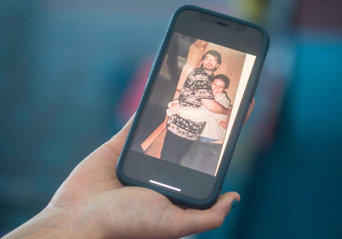 Katie Trout holds up her phone showing a picture of her with James Edward Baker, a former employee of Calvary Church in Charlotte, N.C., who sexually abused her for years, starting at age 15. Trout, who now lives in Raleigh, agreed in a settlement not to publicly name the church. The News & Observer found the church’s name in court documents.