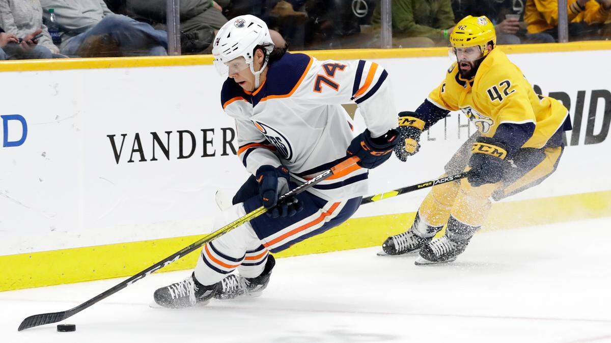 Edmonton Oilers defenseman Ethan Bear (74) moves the puck ahead of Nashville Predators center Colin Blackwell (42) in the second period of an NHL hockey game Monday, March 2, 2020, in Nashville, Tenn. (AP Photo/Mark Humphrey)