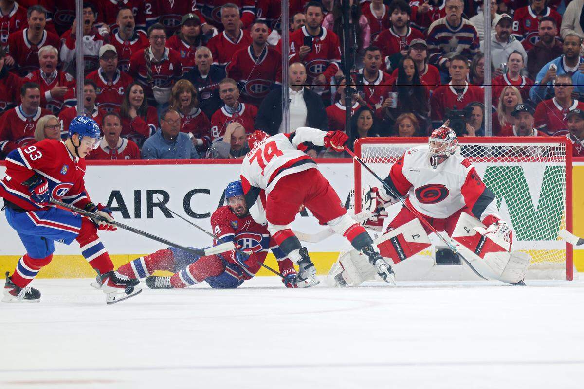Ivan Demidov (93) of the Montreal Canadiens attempts to control the puck as Jaccob Slavin (74) of the Carolina Hurricanes collides with the Canadiens’ Nick Suzuki during the first period in Game 4 of the Eastern Conference Final of the 2026 Stanley Cup Playoffs at Bell Centre on May 27, 2026 in Montreal, Quebec, Canada.