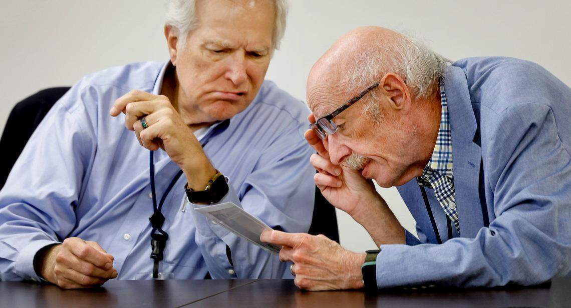 Wake County Board of Elections members Keith Weatherly, left, and Gerry Cohen inspect an absentee ballot during a board meeting at the Wake County Board of Elections Operations Center in Raleigh, N.C., Tuesday, Oct. 8, 2024.