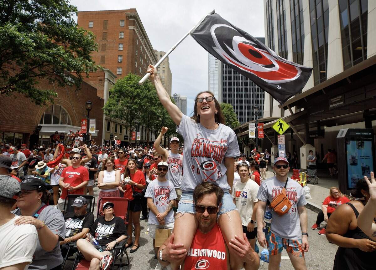 Jayne Vecchio waves a Carolina Hurricanes flag during a rally honoring the team’s 2026 Stanley Cup victory on Saturday, June 20, 2026, on Fayetteville Street in Raleigh, N.C.