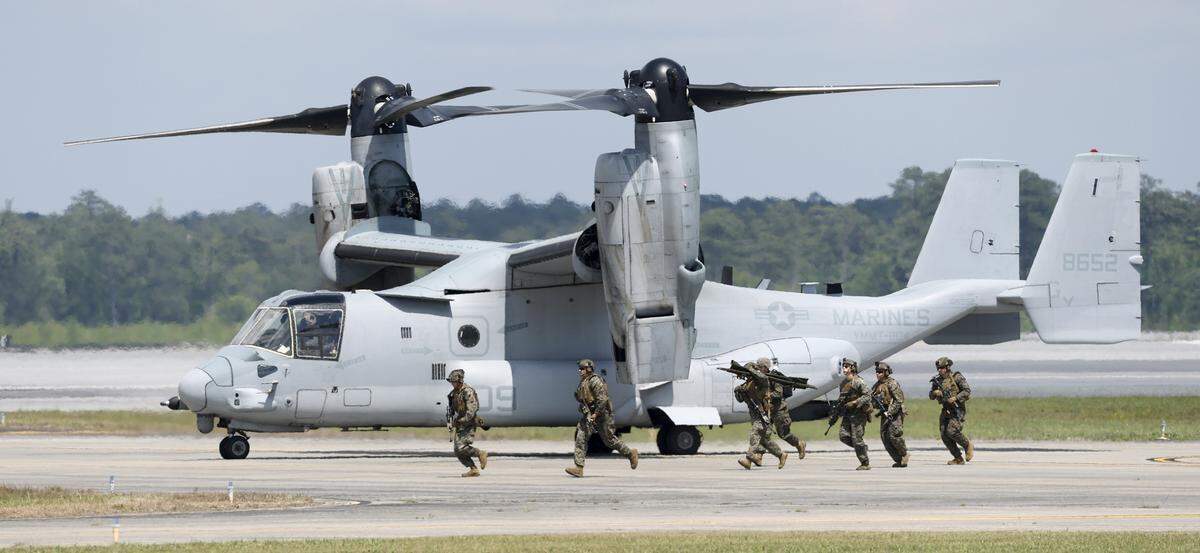 Marines pass by a MV-22 Osprey waiting to take off during a Marine Air-Ground Task Force demonstration in the MCAS Cherry Point Air Show in Havelock, N.C., Sunday, May 10, 2026.