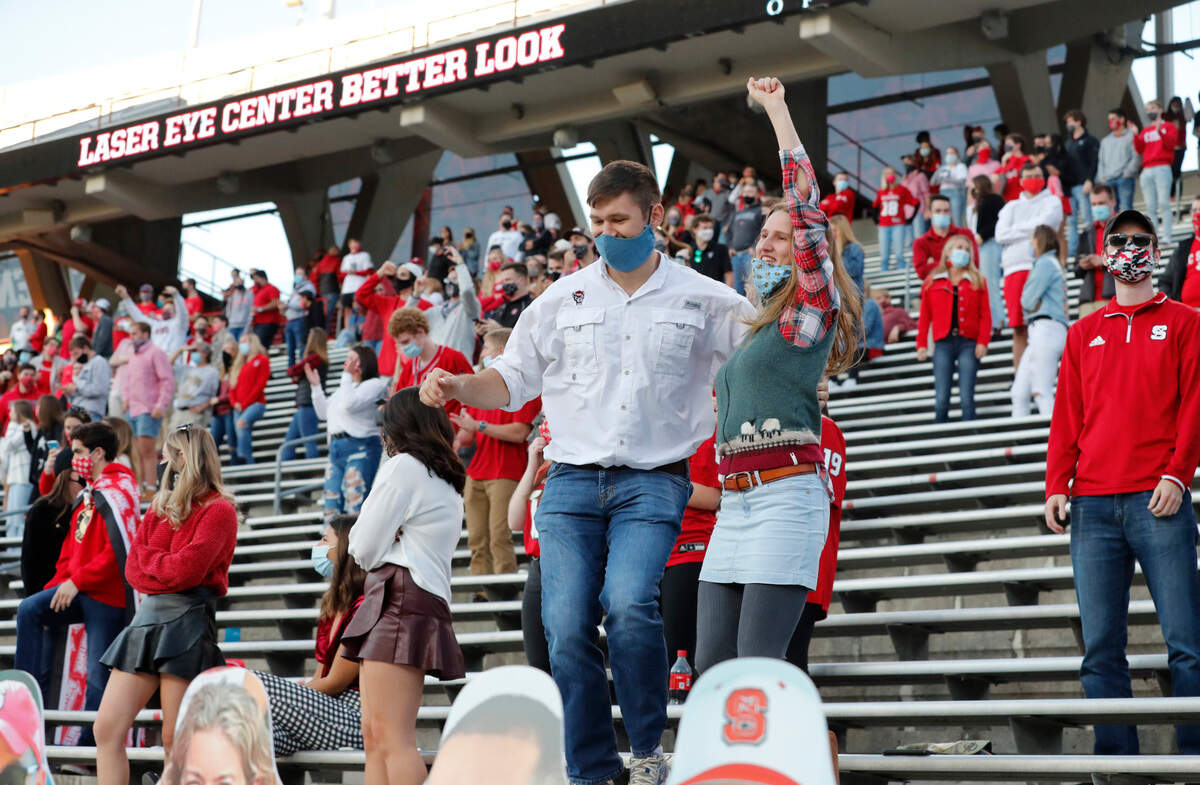 N.C. State fans celebrate during the second half of N.C. State’s 31-20 victory over Duke at Carter-Finley Stadium in Raleigh, N.C., Saturday, Oct. 17, 2020.