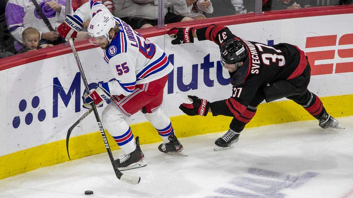 Carolina Hurricanesí Andrei Svechnikov (37) loses his stick as he battles for the puck with New York Rangersí Ryan Lindgren (55) in the first period on Friday, May 20, 2022 during game two of the Stanley Cup second round at PNC Arena in Raleigh, N.C
