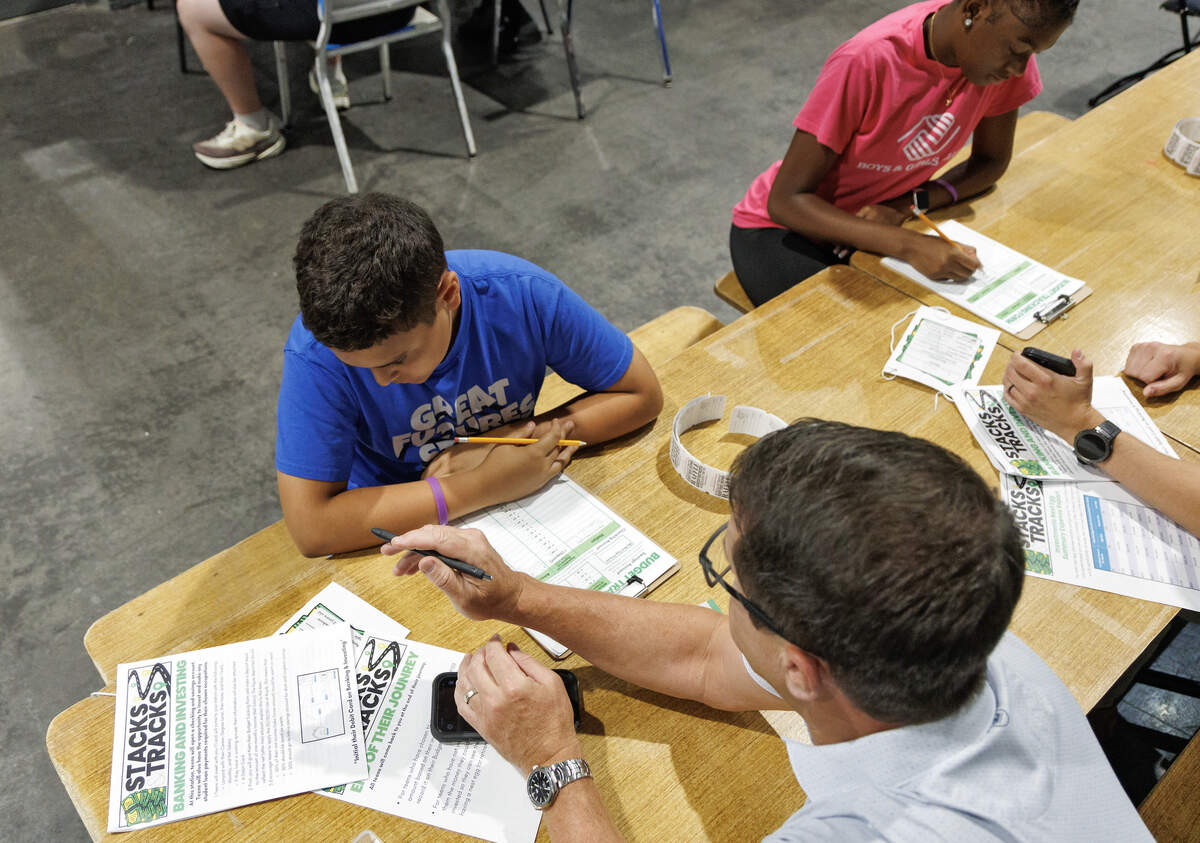 Dom C., left, works with Anthony Cobb to establish a monthly budget during Stacks and Tracks, an event hosted by the Boys and Girls Clubs of Wake and Johnston Counties, on June 29, 2026, in Raleigh.