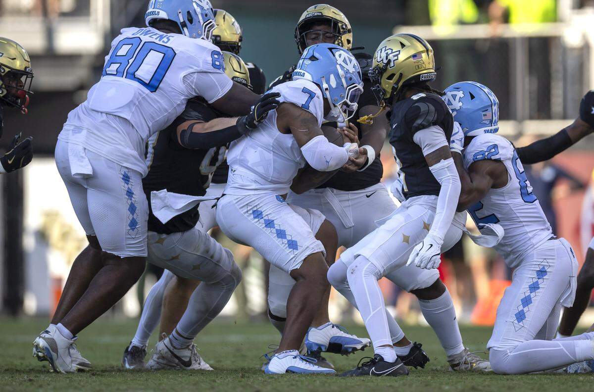 North Carolina quarterback Gio Lopez (7) is stopped by UCF defensive tackle R.J. Jackson Jr. (95) after a gain of one yard for a first down in the third quarter on Saturday, September 20, 2025 in Orlando, Fla. Lopez was injured on the play and did not finish the game. 