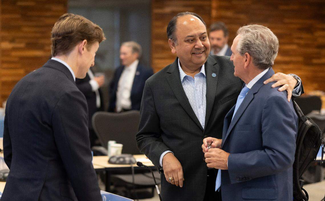UNC Board of Trustee member Vinay B. Patel embraces North Carolina Athletic Director Bubba Cunningham following his presentation to the board on Wednesday, May 21, 2025 in Chapel Hill, N.C.