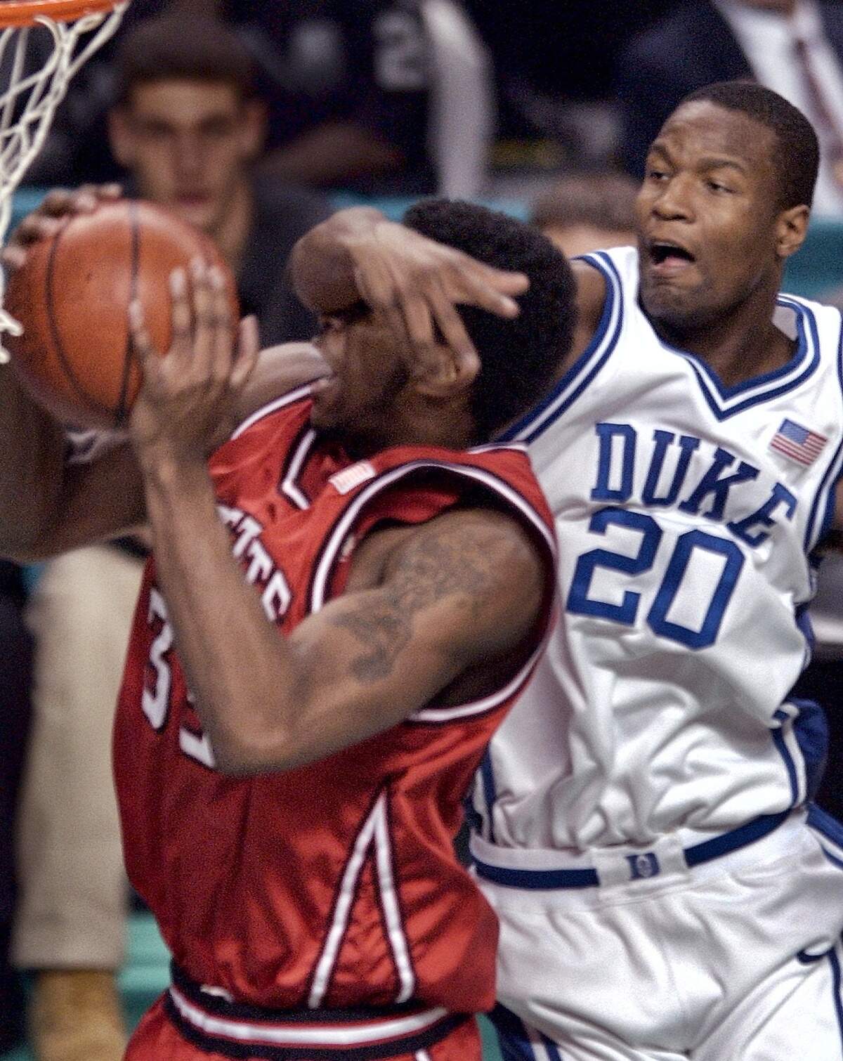 Duke’s Casey Sanders catches NC State’s Josh Powell across the face as Powell grabs a rebound in first half action in the ACC Tournament championship game Sunday, March 16, 2003. No foul was called.