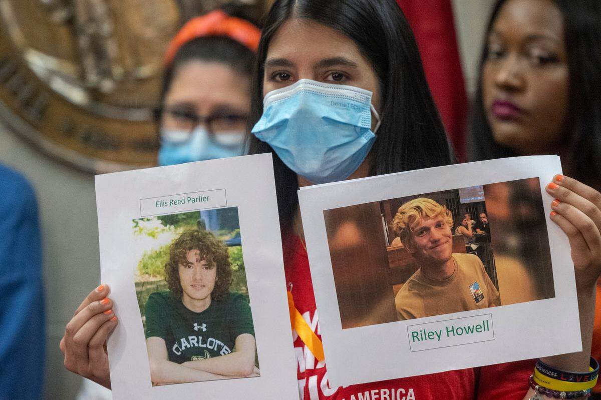 Leah Krevat of Students Demand Action holds a photograph of Reed Parlier and Riley Howell during a press conference demanding gun legislation at the General Assembly Thursday, June 9, 2022 after the mass shooting at Robb Elementary School in Uvalde, Texas. Parlier and Howell were killed by a gunman on the campus at UNC Charlotte in 2019.