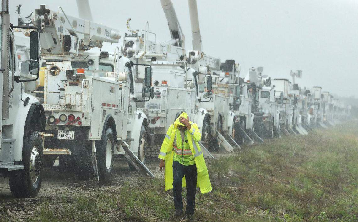 Charles Starling, a lineman with Team Fishel, is pelted with rain as he walks by a row of electrical line trucks staged in a field in The Villages, Florida, on Thursday, Sept. 26, 2024. Thousands of the trucks are staged by Duke Energy in preparation for damage from Hurricane Helene.