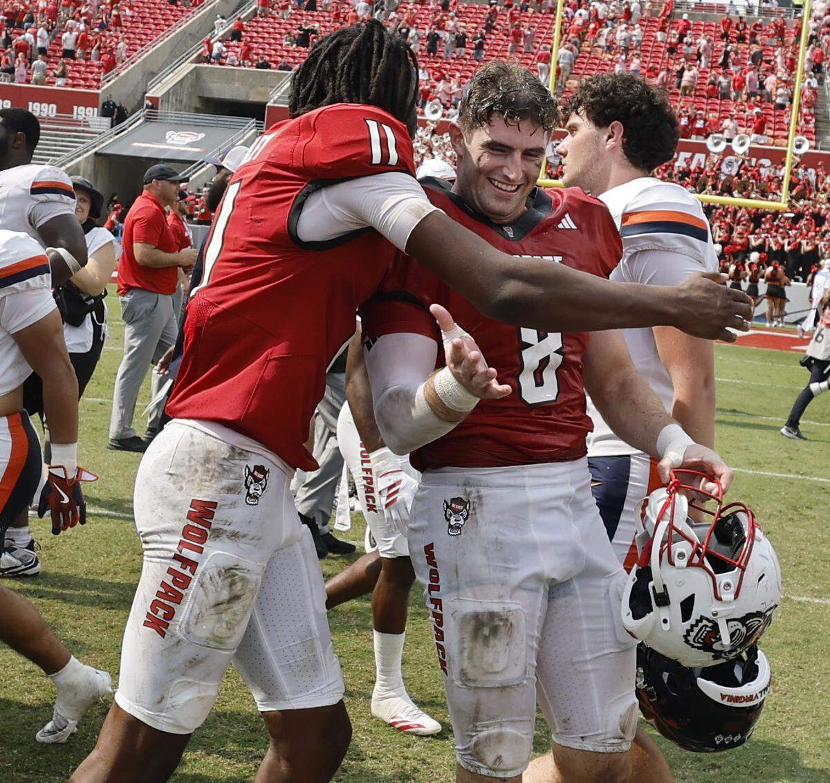 N.C. State quarterback CJ Bailey (11) celebrates with Cian Slone (8) after N.C. State’s 35-31 victory over Virginia at Carter-Finley Stadium in Raleigh, N.C., Sat. Sept. 6, 2025.