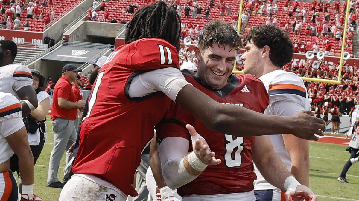 N.C. State quarterback CJ Bailey (11) celebrates with Cian Slone (8) after N.C. State’s 35-31 victory over Virginia at Carter-Finley Stadium in Raleigh, N.C., Sat. Sept. 6, 2025.