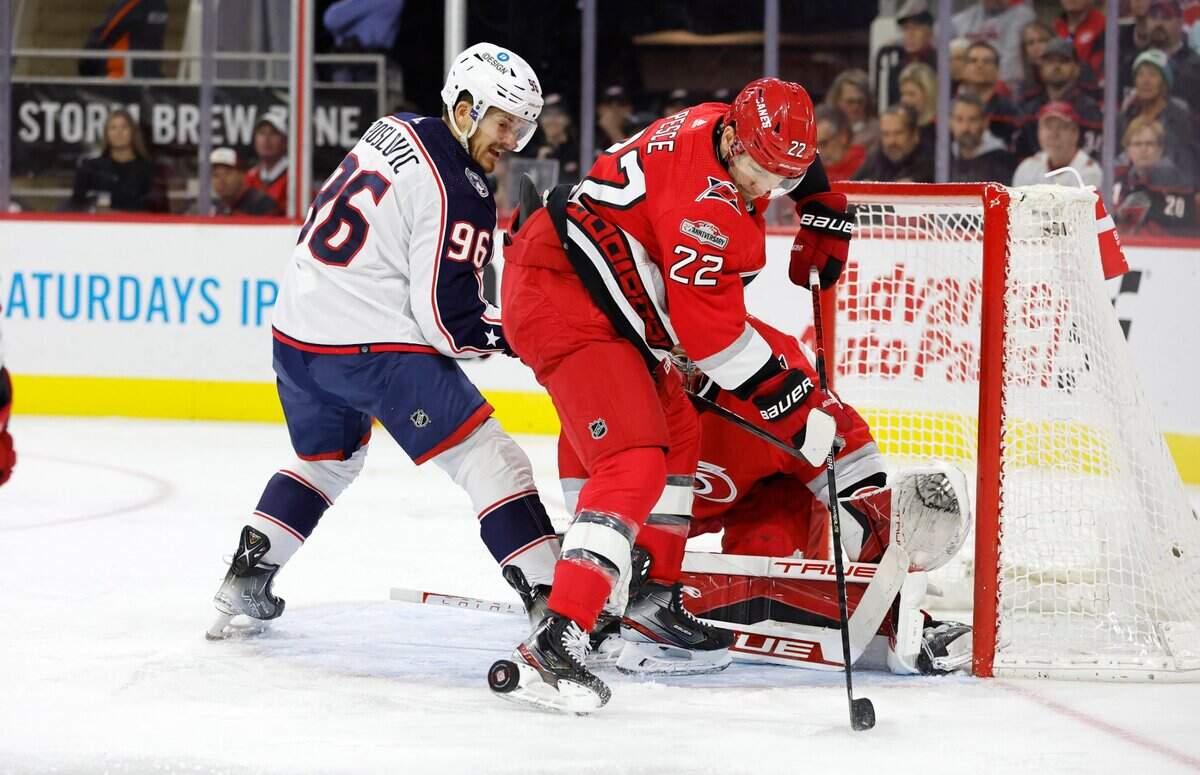 Carolina defenseman Brett Pesce (22) keeps the puck away from Columbus center Jack Roslovic (96) during the first period of the Carolina Hurricanes game against the Columbus Blue Jackets at PNC Arena in Raleigh, N.C., Wednesday, Oct. 12, 2022.