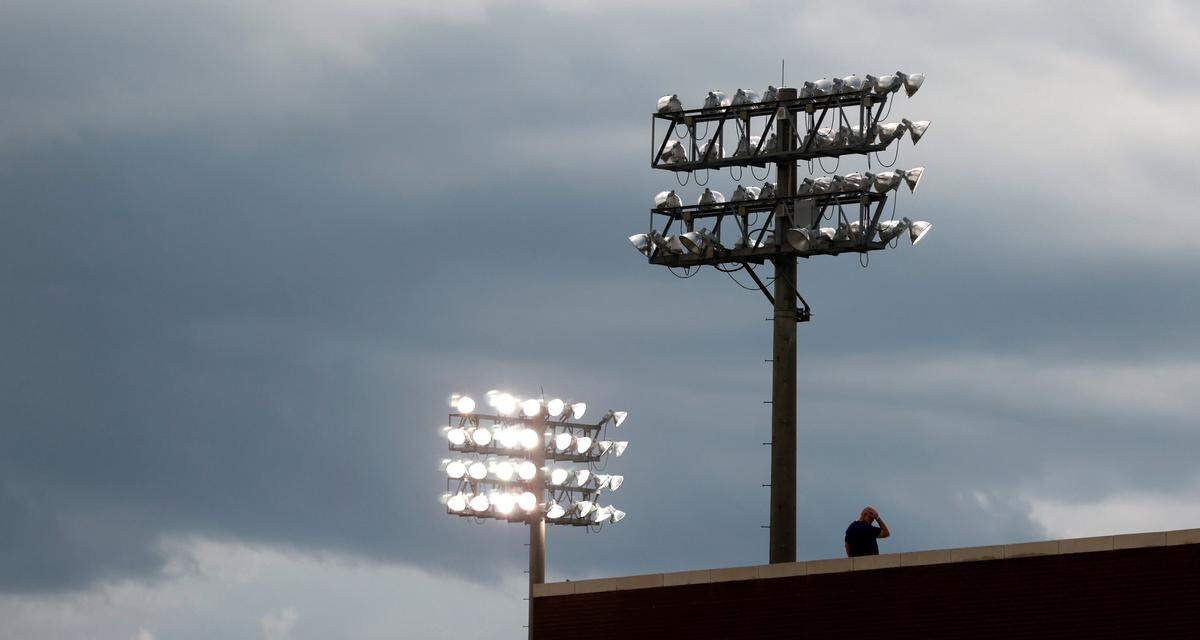 A fan waits out the weather delay in the first inning during ECUs game against Texas in the Greenville Super Regional at Clark-LeClair Stadium Sunday, June 12, 2022.