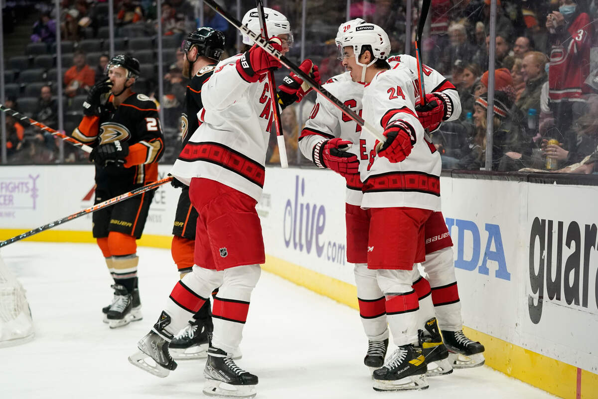 Carolina Hurricanes right wing Andrei Svechnikov (37), right wing Sebastian Aho (20) and center Seth Jarvis (24) celebrate after Jarvis scored a goal during the third period of an NHL hockey game against the Anaheim Ducks in Anaheim, Calif., Thursday, Nov. 18, 2021. (AP Photo/Ashley Landis)