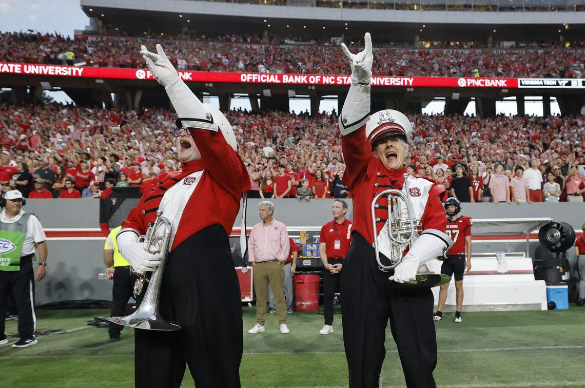N.C. State Marching Band member Lois Roegge, 58, right, cheers with the band after marching out onto the field before N.C. State’s game against Virginia Tech at Carter-Finley Stadium in Raleigh, N.C., Saturday, Sept. 27, 2025.