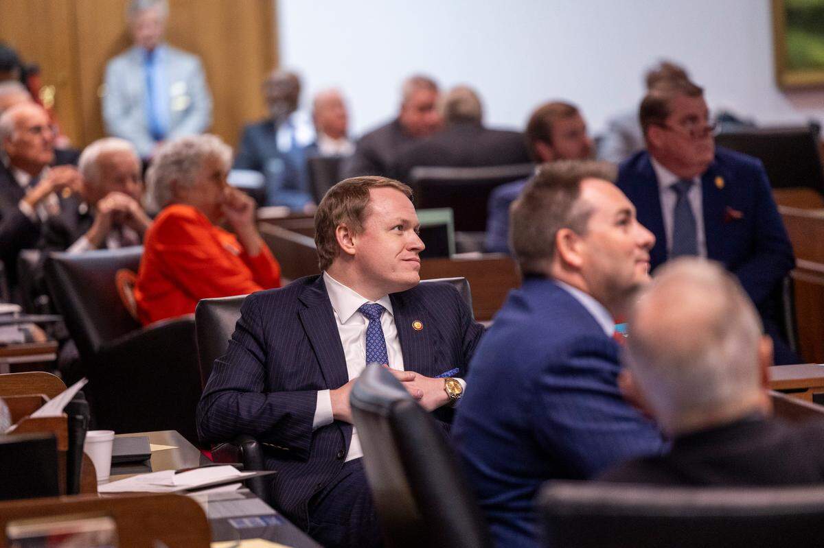 Lawmakers, including Republican Rep. Destin Hall, who represents Caldwell and Watauga counties, center, watch as police remove demonstrators from the House gallery on Dec. 11, 2024, at the North Carolina Legislative Building. 