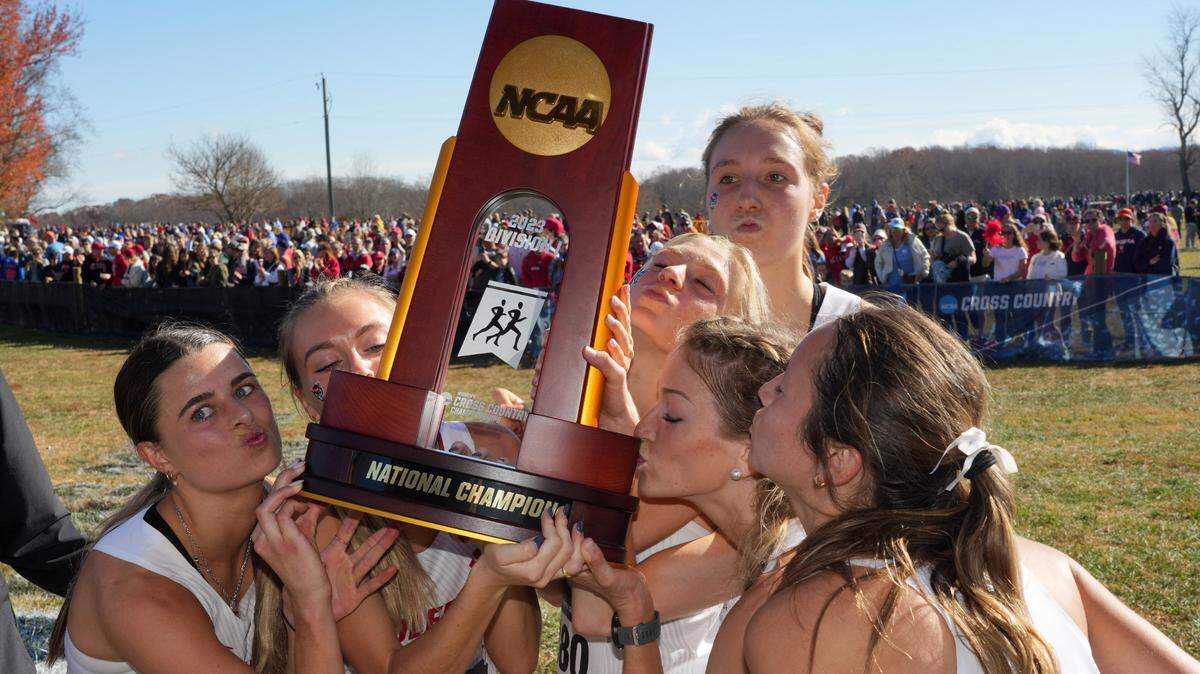 Members of the NC State Wolfpack women’s team kiss the championship trophy after winning the team title during the NCAA cross country championships at Panorama Farms. Mandatory Credit: Kirby Lee-USA TODAY Sports