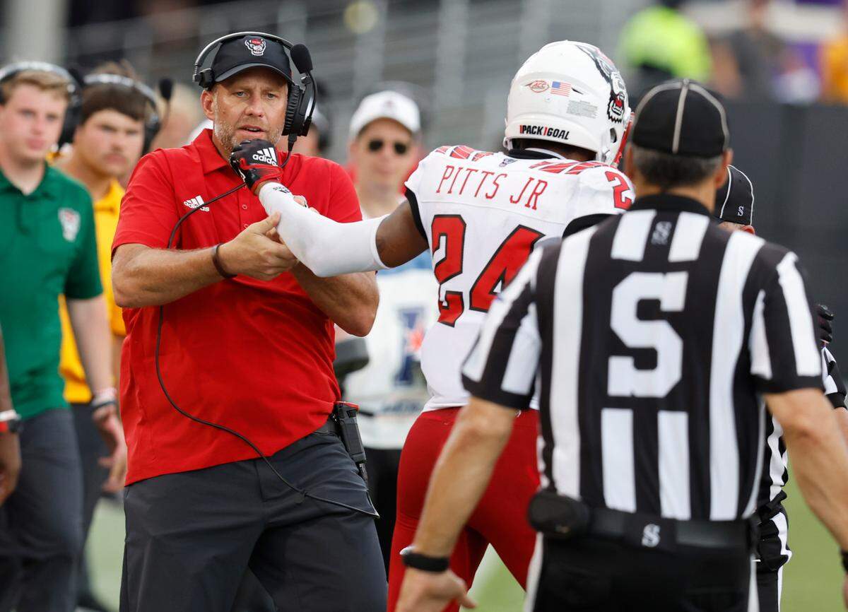N.C. State head coach Dave Doeren pulls cornerback Derrek Pitts Jr. (24) away from East Carolina wide receiver Isaiah Winstead (11) during the second half of N.C. State’s 21-20 victory over ECU at Dowdy-Ficklen Stadium in Greenville, N.C., Saturday, Sept. 3, 2022.