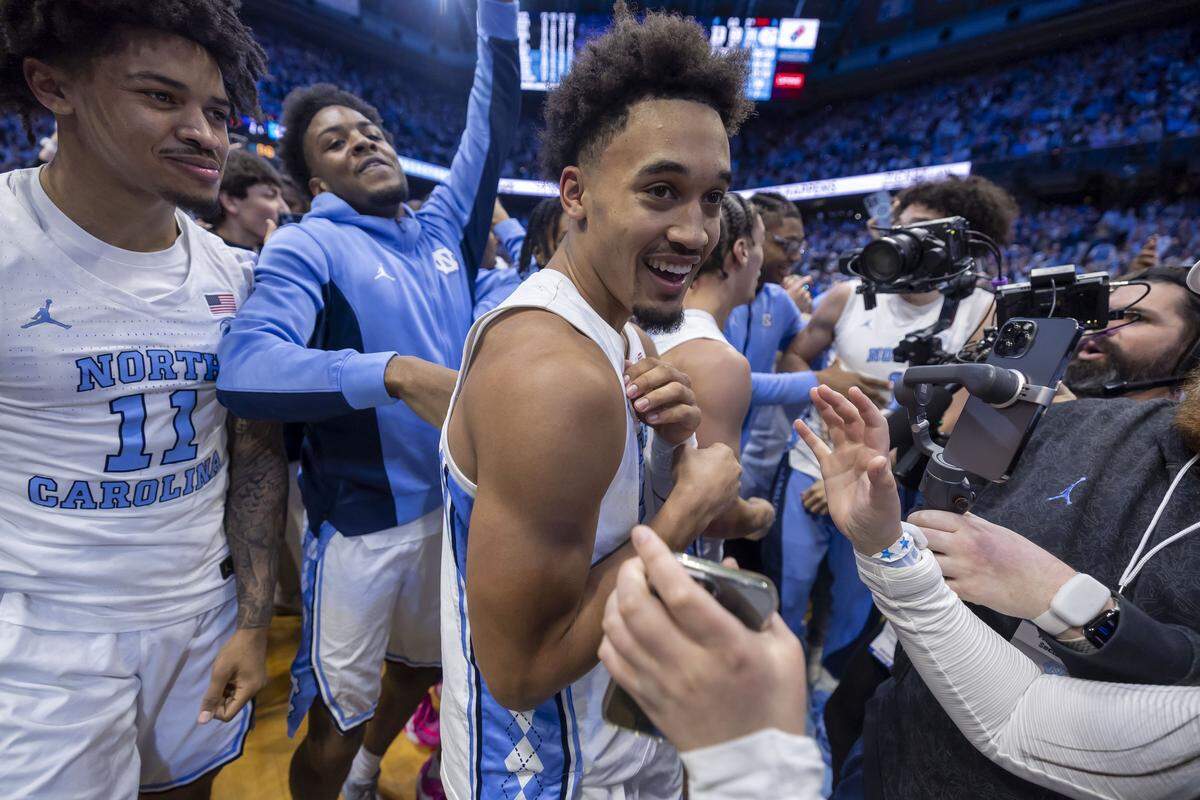North Carolina guard Seth Trimble (7) reacts as fans storm the court, after sinking a three-point shot with .4 seconds to play, to give the Tar Heels a 71-68 victory over Duke on Saturday, February 7, 2026 at the Smith Center in Chapel Hill, N.C.