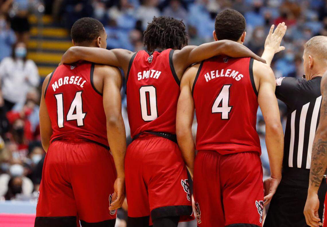 N.C. State’s Terquavion Smith (0) walks back to the bench with Casey Morsell (14) and Jericole Hellems (4) after a timeout is called during UNC’s 100-80 victory over N.C. State at the Smith Center in Chapel Hill, N.C., Saturday, Jan. 29, 2022.