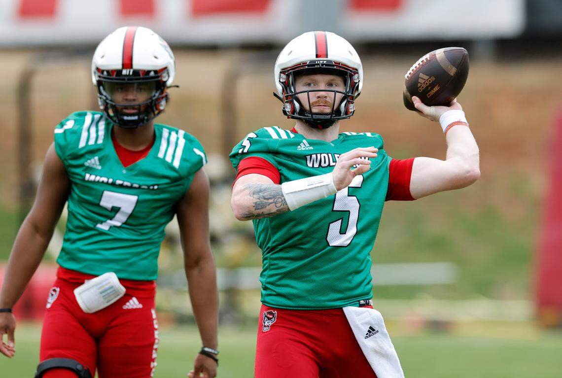 N.C. State quarterback Brennan Armstrong (5) throws as N.C. State quarterback MJ Morris (7) watches during the Wolfpack’s first spring practice in Raleigh, N.C., Wednesday, March 1, 2023.