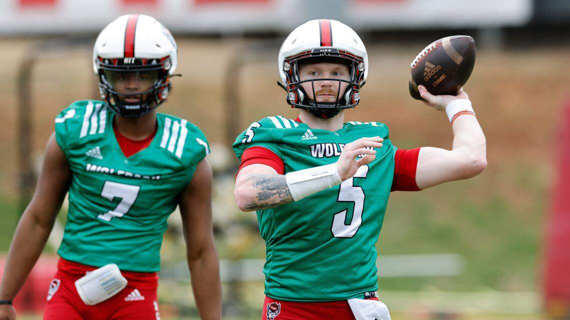 N.C. State quarterback Brennan Armstrong (5) throws as N.C. State quarterback MJ Morris (7) watches during the Wolfpack’s first spring practice in Raleigh, N.C., Wednesday, March 1, 2023.