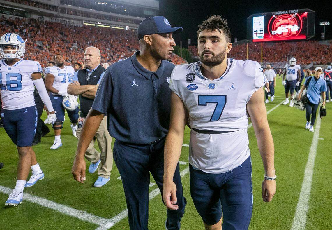North Carolina wide receivers coach Lonnie Galloway has a word with North Carolina quarterback Sam Howell (7) as they leave the field following their 17-10 loss to Virginia Tech on Friday, September 3, 2021 at Lane Stadium in Blacksburg, Va. Howell was sacked six times by the Virginia Tech defense and threw three interceptions.