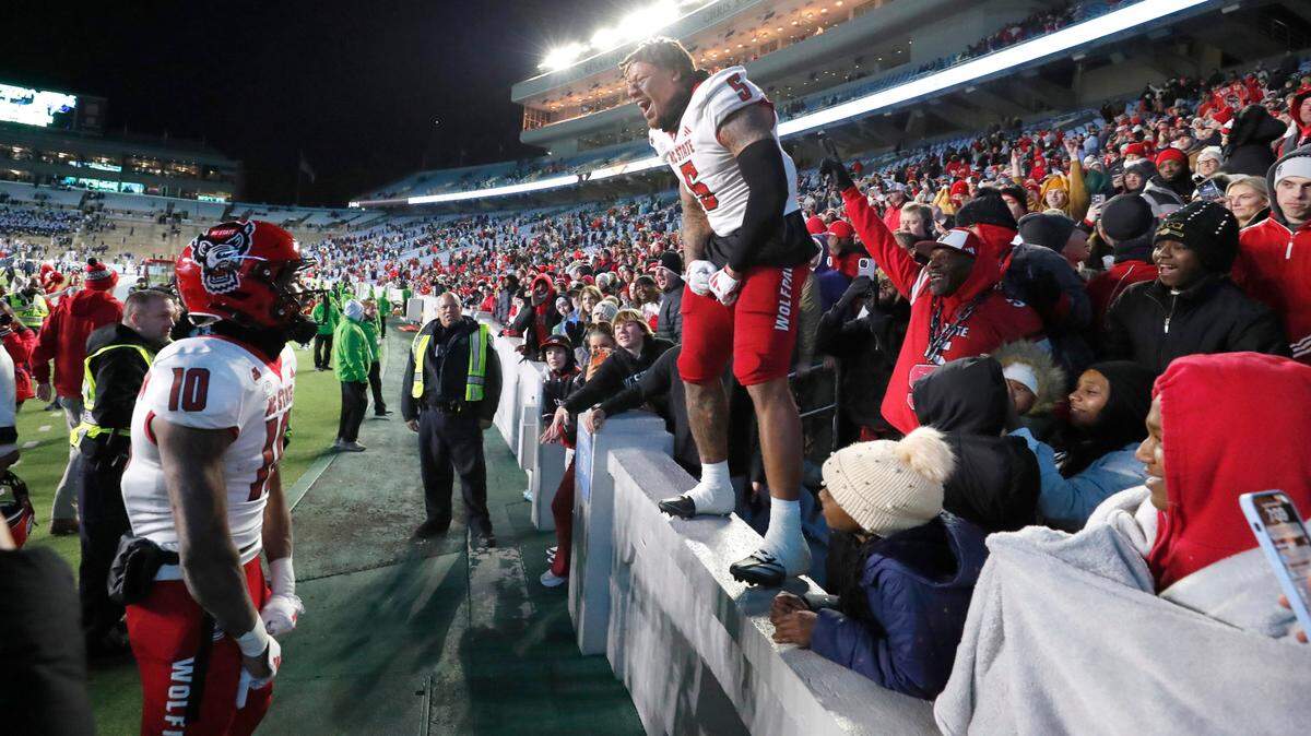 N.C. State’s DK Kaufman (5) celebrates with KC Concepcion (10) after the Wolfpack’s 35-30 victory over UNC at Kenan Stadium in Chapel Hill, N.C., Saturday, Nov. 30, 2024.